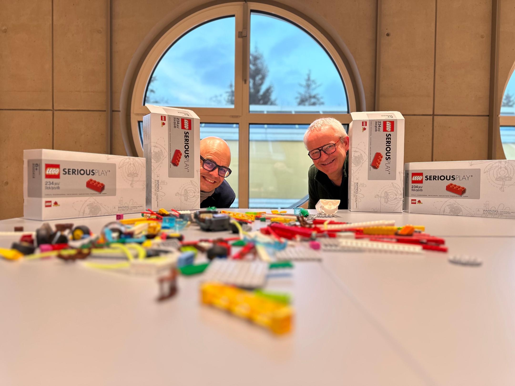 Zwei Männer arbeiten mit Legosteinen nach der Methode LEGO SERIOUS PLAY