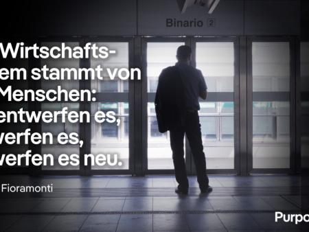 Lorenzo Fioramonti steht in einem gläsernen Bereich vor dem Einstieg in eine U-Bahn, darauf sein Zitat: 'Das Wirtschaftssystem stammt von uns Menschen: Wir entwerfen es, verwerfen es, entwerfen es neu.'