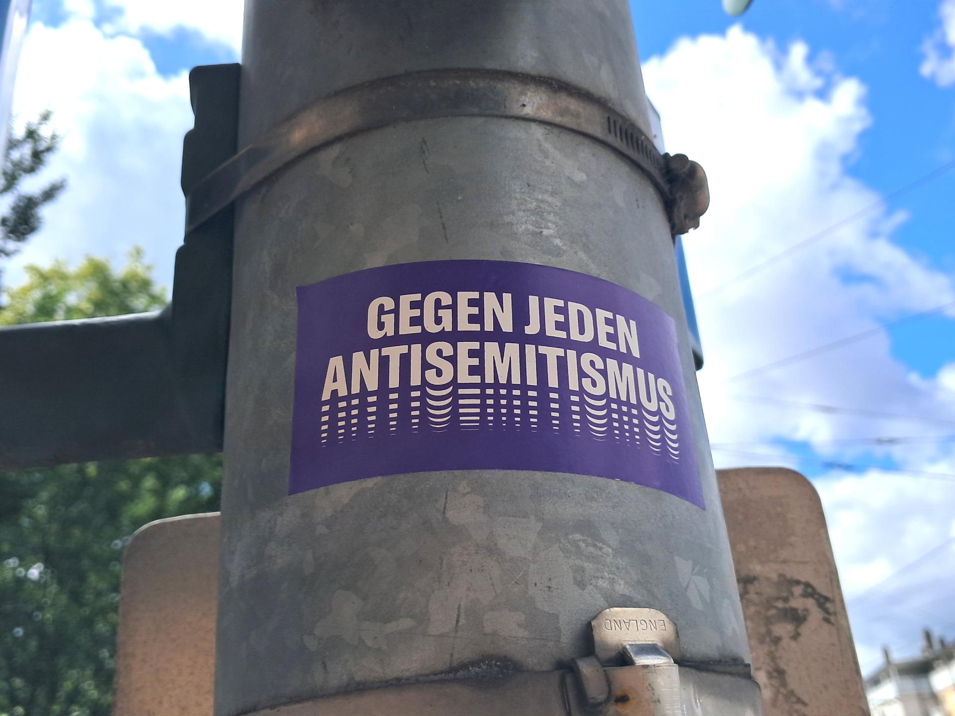 Aufkleber auf einer Straßenlaterne: 'Gegen jeden Antisemitismus.'