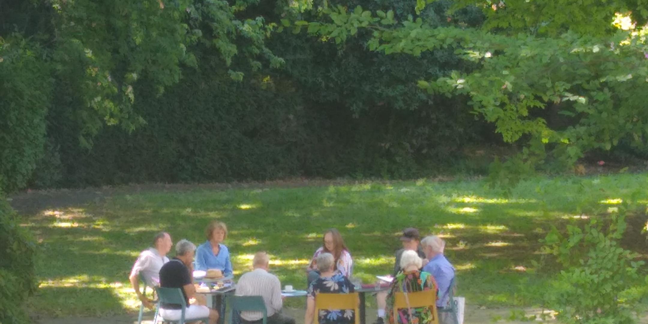 Die Arbeitsgruppe eines Seminars sitzt unter Bäumen im Schatten und arbeitet an einem Bibeltext.