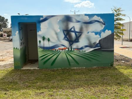 Wandgemälde im Kibbutz Kerem-Shalom (c) Roded Shlomo Pikiwiki Israel Ein bemaltes Gebäude mit Palmen und einem Davidsstern.