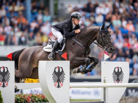 (c) CHIO Aachen Springreiter auf dem Pferd springt über ein Hindernis auf dem Parcours.