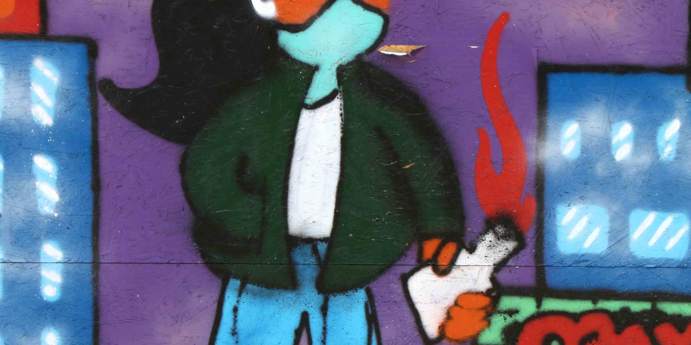 Graffiti, an eine Mauer gesprayt, zeigt ein Mädchen mit einem Brennsatz in der Hand