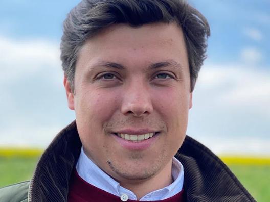 Porträt eines Mannes, es zeigt den Pfarrer Justus Geilhufe vor einer Landschaft