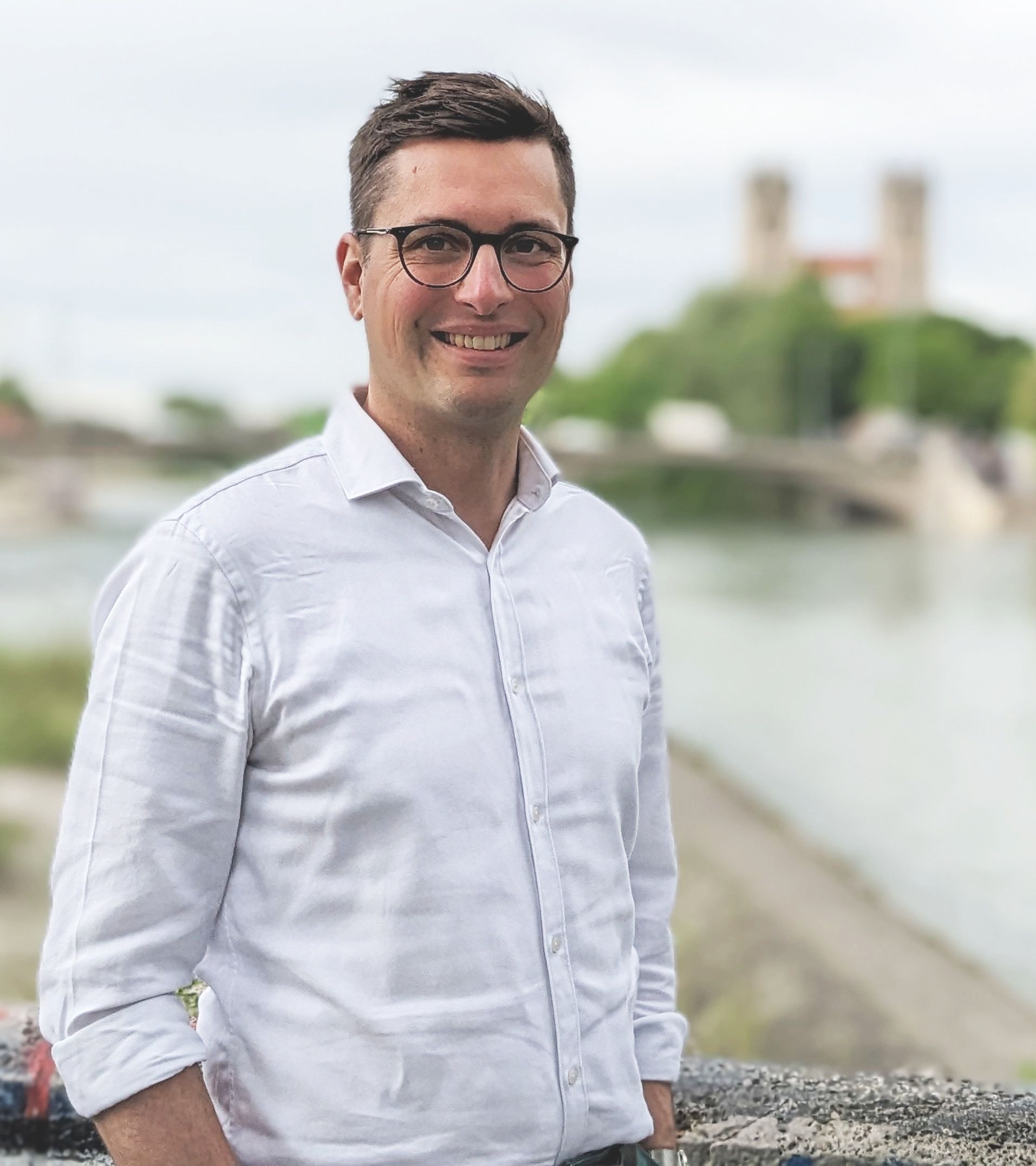 Ein Mann mit Brille vor Landschaft.