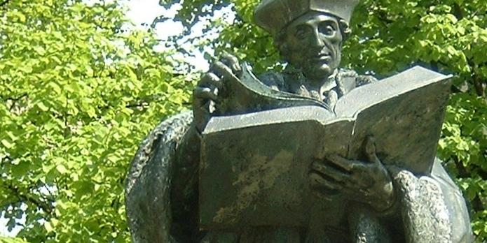 Eine Bronzestatue zeigt Erasmus von Rotterdam (ca. 1467-1536), lesend in einem großen bronzenen Buch.