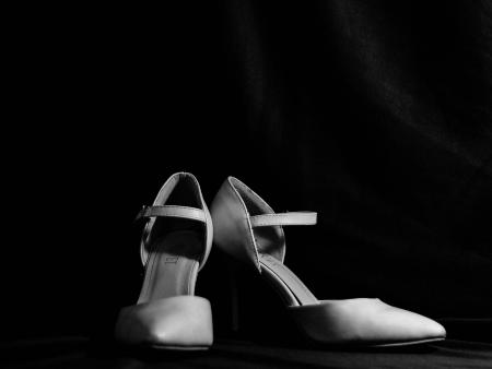 krystal-ng-XSEvOX6UI5E-unsplash (c) Krystal Ng/unsplash.de Ein Paar Frauenschuhe, hohe Pumps, vor schwarzem Hintergrund.