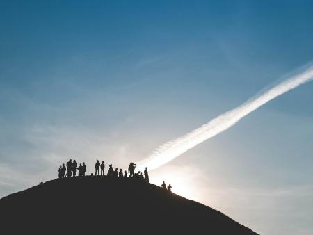 Suche nach Frieden (c) Mariusz Slonski/unsplash Eine Gruppe von Menschen steht auf einem Hügel und schaut in den Himmel.