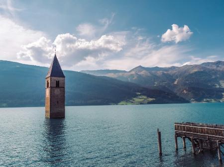 Kirchturm ragt aus der Wasseroberfläche, das Gebäude scheint darunter zu liegen