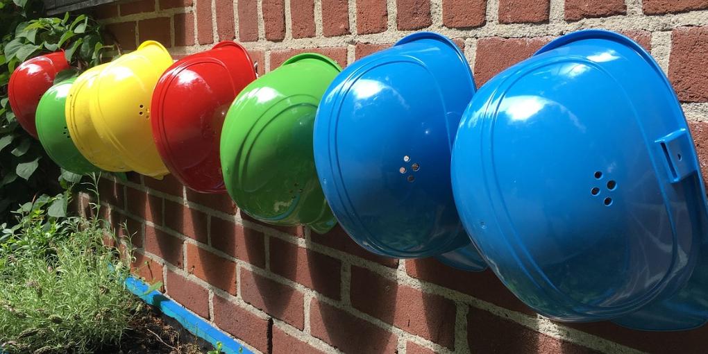 Eine Reihe von Helmen hängt an einer Wand.